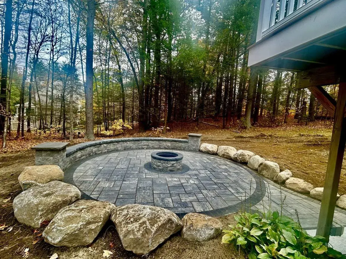 Round fire pit patio framed with boulders