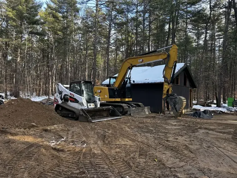 Excavator and skid steer clearing a building site