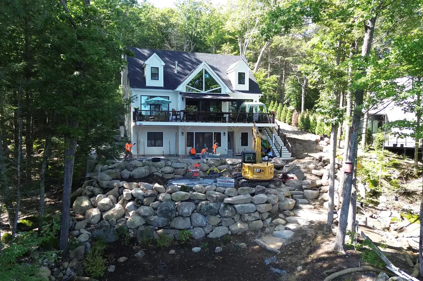 Boulder retaining wall built below a lakefront home