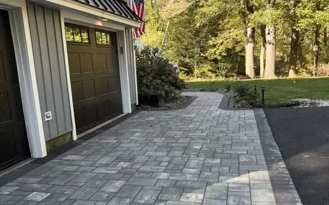 Paver walkway with a border running along the garage